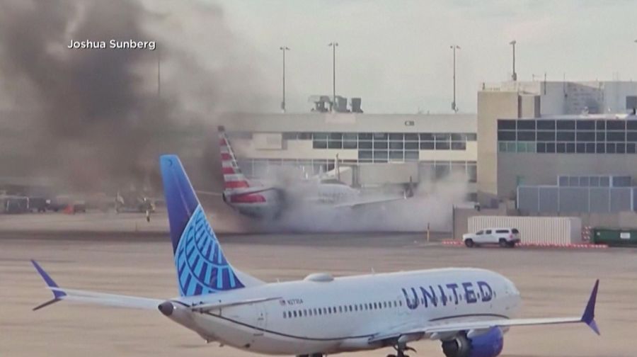 Asap mengepul setelah salah satu mesin pesawat American Airlines terbakar di Bandara Internasional Denver pada Kamis (13/3/2025) malam. (Tangkapan Layar Video AFP/Joshua Sunberg via CBS)