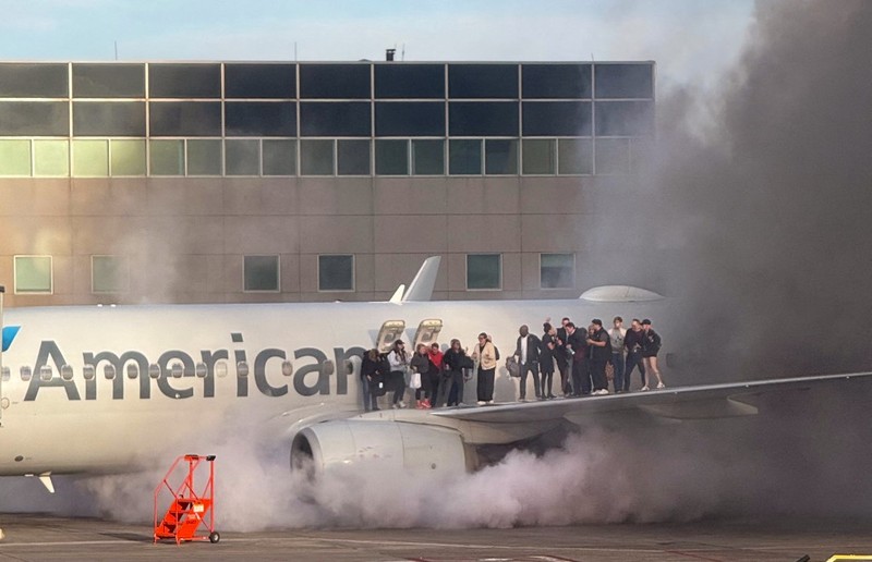 Asap mengepul setelah salah satu mesin pesawat American Airlines terbakar di Bandara Internasional Denver pada Kamis (13/3/2025) malam. Asap mengepul setelah salah satu mesin pesawat American Airlines terbakar di Bandara Internasional Denver pada Kamis (13/3/2025) malam. (Tangkapan Layar Video AFP/Joshua Sunberg via CBS)