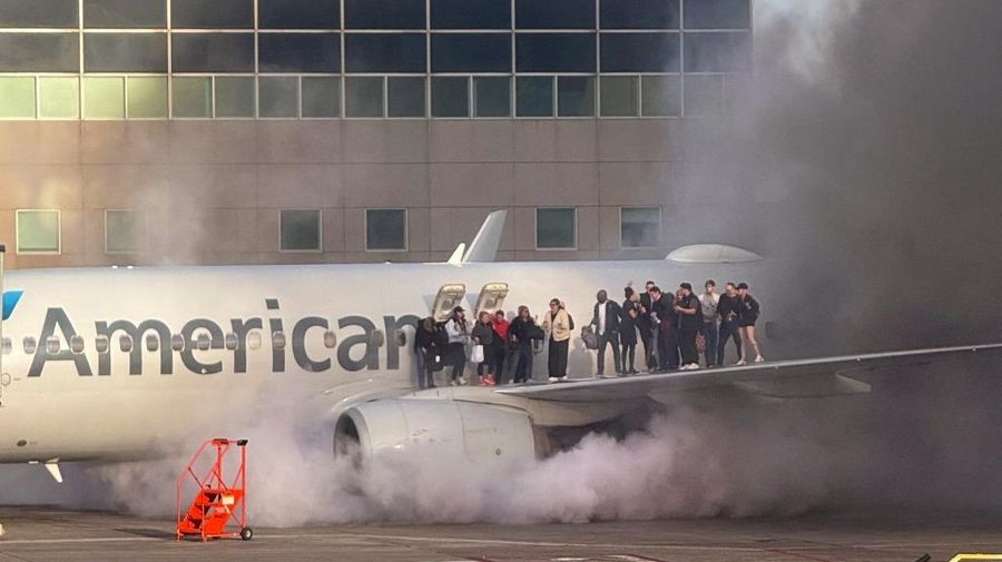 Asap mengepul setelah salah satu mesin pesawat American Airlines terbakar di Bandara Internasional Denver pada Kamis (13/3/2025) malam. (Tangkapan Layar Video AFP/Joshua Sunberg via CBS)