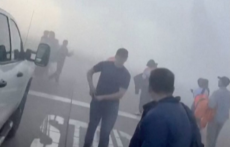 Asap mengepul setelah salah satu mesin pesawat American Airlines terbakar di Bandara Internasional Denver pada Kamis (13/3/2025) malam. (Tangkapan Layar Video AFP/Joshua Sunberg via CBS)