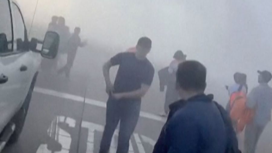 Asap mengepul setelah salah satu mesin pesawat American Airlines terbakar di Bandara Internasional Denver pada Kamis (13/3/2025) malam. (Tangkapan Layar Video AFP/Joshua Sunberg via CBS)