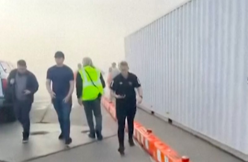 Asap mengepul setelah salah satu mesin pesawat American Airlines terbakar di Bandara Internasional Denver pada Kamis (13/3/2025) malam. Asap mengepul setelah salah satu mesin pesawat American Airlines terbakar di Bandara Internasional Denver pada Kamis (13/3/2025) malam. (Tangkapan Layar Video AFP/Joshua Sunberg via CBS)