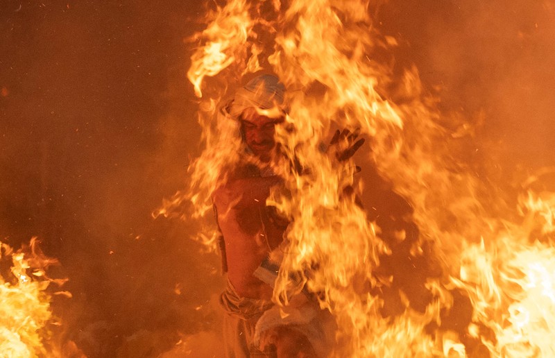 Umat Hindu berjalan mengelilingi api unggun selama ritual yang dikenal sebagai Umat Hindu berjalan mengelilingi api unggun selama ritual yang dikenal sebagai