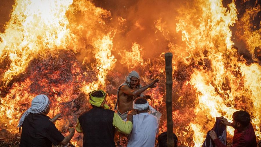 Umat ​​Hindu berjalan mengelilingi api unggun selama ritual yang dikenal sebagai 