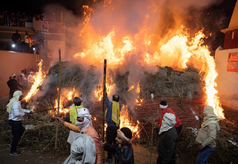 Umat Hindu berjalan mengelilingi api unggun selama ritual yang dikenal sebagai Umat Hindu berjalan mengelilingi api unggun selama ritual yang dikenal sebagai