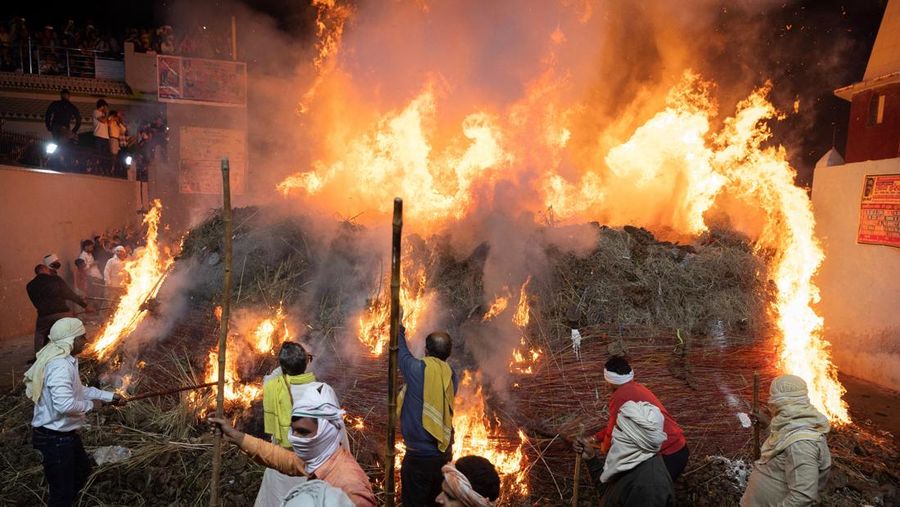 Umat ​​Hindu berjalan mengelilingi api unggun selama ritual yang dikenal sebagai 