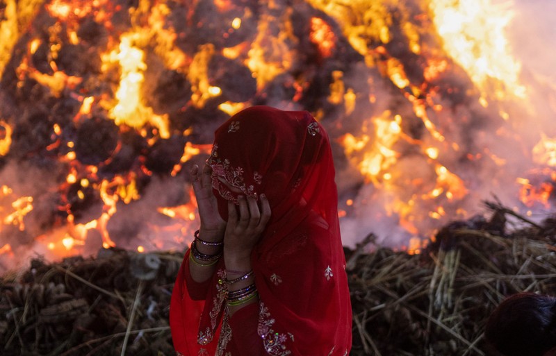 Umat ​​Hindu berjalan mengelilingi api unggun selama ritual yang dikenal sebagai 