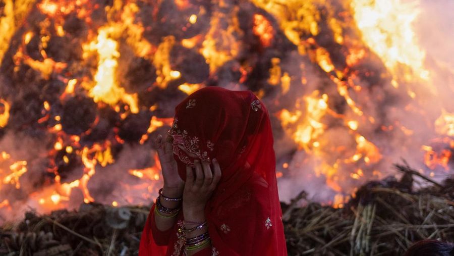 Umat ​​Hindu berjalan mengelilingi api unggun selama ritual yang dikenal sebagai 