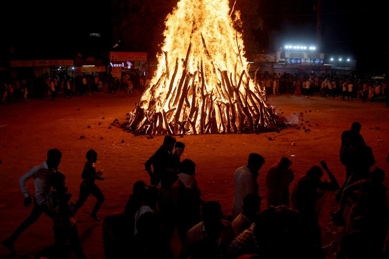 Umat Hindu berjalan mengelilingi api unggun selama ritual yang dikenal sebagai Umat Hindu berjalan mengelilingi api unggun selama ritual yang dikenal sebagai
