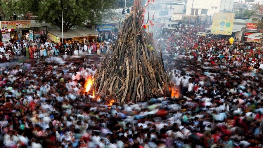 Umat ​​Hindu berjalan mengelilingi api unggun selama ritual yang dikenal sebagai 