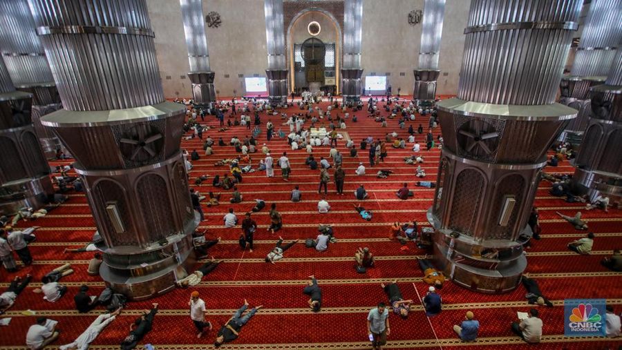 Warga menunggu waktu berbuka puasa (ngabuburit) dengan membaca Al Quran di Masjid Istiqlal, Jakarta, Jumat (14/3/2025). Masjid yang dibangun pada 1961 atau masa pemerintahan Presiden pertama RI Soekarno itu menjadi lokasi favorit masyarakat menunggu waktu berbuka puasa karena letaknya yang strategis di pusat kota Jakarta. (CNBC Indonesia/Faisal Rahman)