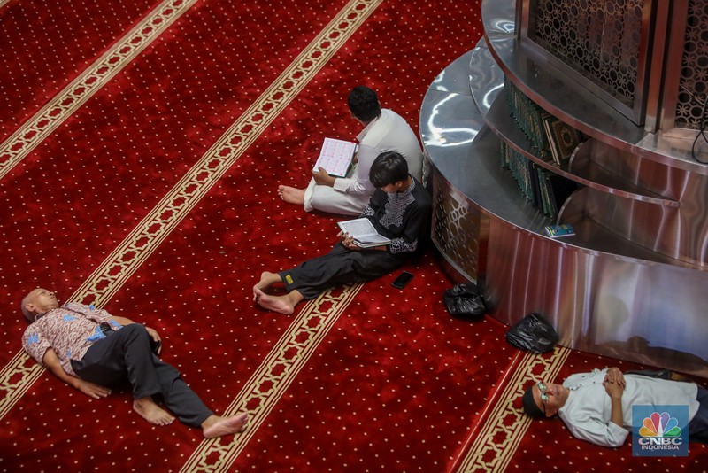 Warga menunggu waktu berbuka puasa (ngabuburit) dengan membaca Al Quran di Masjid Istiqlal, Jakarta, Jumat (14/3/2025). Masjid yang dibangun pada 1961 atau masa pemerintahan Presiden pertama RI Soekarno itu menjadi lokasi favorit masyarakat menunggu waktu berbuka puasa karena letaknya yang strategis di pusat kota Jakarta. (CNBC Indonesia/Faisal Rahman)