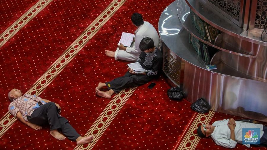 Warga menunggu waktu berbuka puasa (ngabuburit) dengan membaca Al Quran di Masjid Istiqlal, Jakarta, Jumat (14/3/2025). Masjid yang dibangun pada 1961 atau masa pemerintahan Presiden pertama RI Soekarno itu menjadi lokasi favorit masyarakat menunggu waktu berbuka puasa karena letaknya yang strategis di pusat kota Jakarta. (CNBC Indonesia/Faisal Rahman)