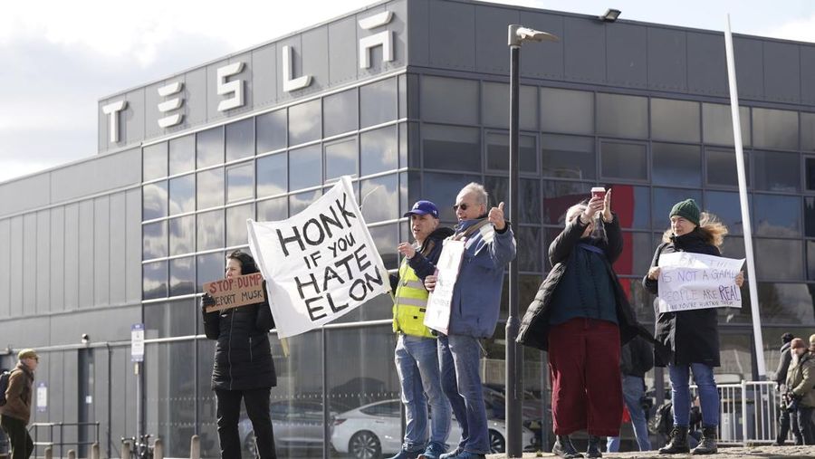 Sejumlah warga melakukan aksi protes di depan kantor pusat Tesla di Park Royal di London barat, Sabtu, 15/3/2025. (Stefan Rousseau/PA via AP)