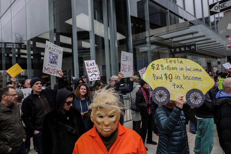USA-TRUMP/TESLA-PROTESTS People protest against Tesla and its CEO Elon Musk outside a Tesla store in New York City, U.S., March 15, 2025. REUTERS/Jeenah Moon