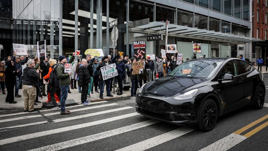 People protest against Tesla and its CEO Elon Musk outside a Tesla store in New York City, U.S., March 15, 2025. REUTERS/Jeenah Moon