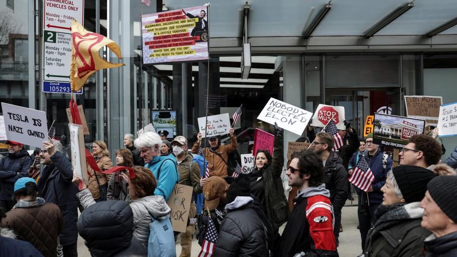 People protest against Tesla and its CEO Elon Musk outside a Tesla store in New York City, U.S., March 15, 2025. REUTERS/Jeenah Moon