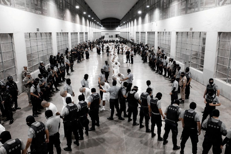 Petugas polisi Penjara, Salvador, Geng, Venezuela, Donald Trump, Migrasi mengawal terduga anggota geng Venezuela Tren de Aragua yang baru-baru ini dideportasi oleh pemerintah AS untuk dipenjara di penjara Pusat Penahanan Terorisme (CECOT), sebagai bagian dari perjanjian dengan pemerintah Salvador, di Tecoluca, El Salvador, dalam gambar selebaran ini yang diperoleh pada tanggal 16 Maret 2025. Petugas polisi Salvador mengawal terduga anggota geng Venezuela Tren de Aragua yang baru-baru ini dideportasi oleh pemerintah AS untuk dipenjara di penjara Pusat Penahanan Terorisme (CECOT), sebagai bagian dari perjanjian dengan pemerintah Salvador, di Tecoluca, El Salvador, dalam gambar selebaran ini yang diperoleh pada tanggal 16 Maret 2025. (Secretaria de Prensa de la Presidencia/Handout via REUTERS)