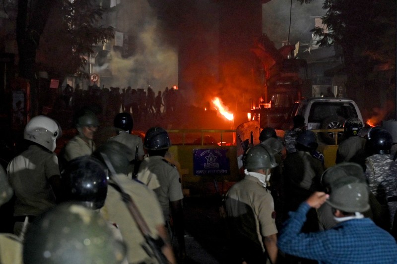 Seorang petugas pemadam kebakaran berdiri di dekat kendaraan yang terbakar setelah bentrokan di kawasan Chitnavis Park Square, Nagpur pada 17 Maret 2025. (AFP) Seorang petugas pemadam kebakaran berdiri di dekat kendaraan yang terbakar setelah bentrokan di kawasan Chitnavis Park Square, Nagpur pada 17 Maret 2025. (AFP)