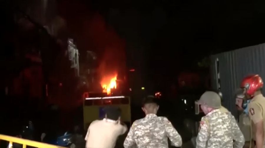 Seorang petugas pemadam kebakaran berdiri di dekat kendaraan yang terbakar setelah bentrokan di kawasan Chitnavis Park Square, Nagpur pada 17 Maret 2025. (AFP)