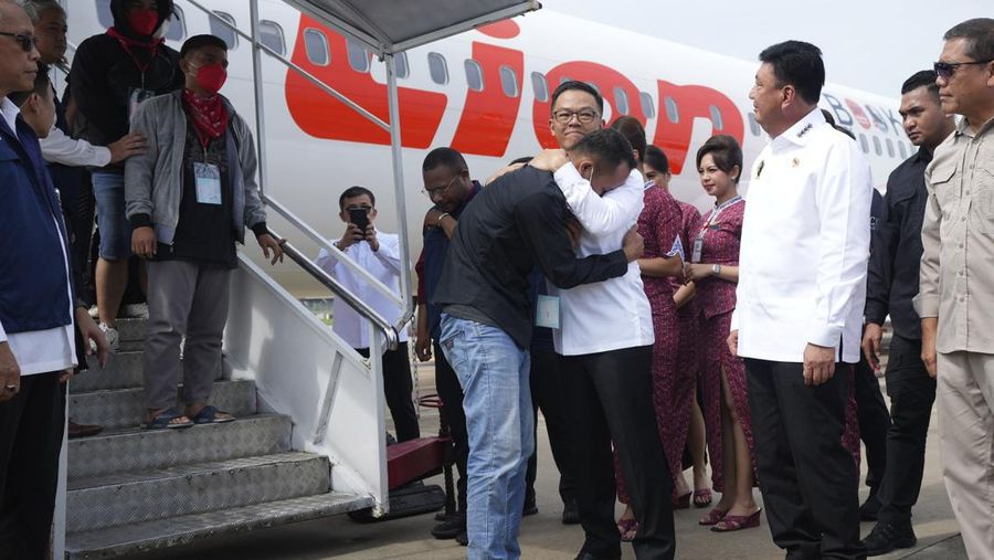 Menteri Luar Negeri Indonesia Sugiono, tengah, memeluk seorang warga negara Indonesia yang baru tiba yang pernah bekerja di pusat penipuan di Myanmar saat Menteri Koordinator Politik, Hukum, dan Keamanan Budi Gunawan, kedua dari kanan, melihat, di Bandara Internasional Soekarno-Hatta di Tangerang, Indonesia, Selasa, 18 Maret 2025. (AP Photo/Tatan Syuflana, Pool)
