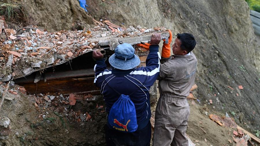 Orang-orang menemukan jenazah kerabat mereka setelah tanah longsor di pemakaman rahasia Ovejuyo yang disebabkan oleh hujan, di kotamadya Palca, Bolivia, 17 Maret 2025. (REUTERS/Claudia Morales)