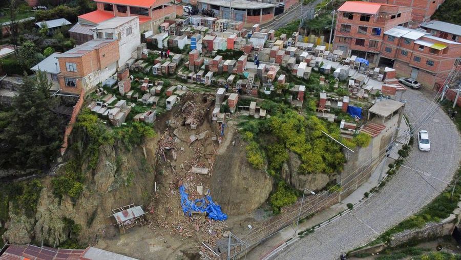 Orang-orang menemukan jenazah kerabat mereka setelah tanah longsor di pemakaman rahasia Ovejuyo yang disebabkan oleh hujan, di kotamadya Palca, Bolivia, 17 Maret 2025. (REUTERS/Claudia Morales)