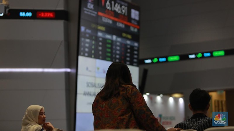 Pengunjung berbincang dibawah layar pergerakan Indeks Harga Saham Gabungan (IHSG) di Bursa Efek Indonesia (BEI), Jakarta, Selasa (18/3/2025). (վ/Muhammad Sabki)