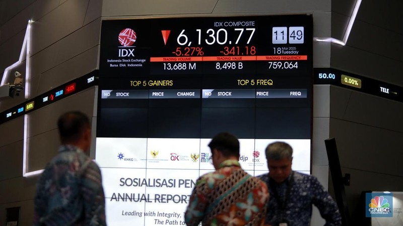 Pengunjung berbincang dibawah layar pergerakan Indeks Harga Saham Gabungan (IHSG) di Bursa Efek Indonesia (BEI), Jakarta, Selasa (18/3/2025). (վ/Muhammad Sabki)
