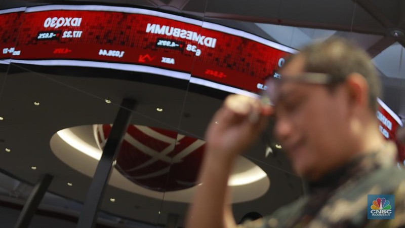 Pengunjung berbincang dibawah layar pergerakan Indeks Harga Saham Gabungan (IHSG) di Bursa Efek Indonesia (BEI), Jakarta, Selasa (18/3/2025). (վ/Muhammad Sabki)