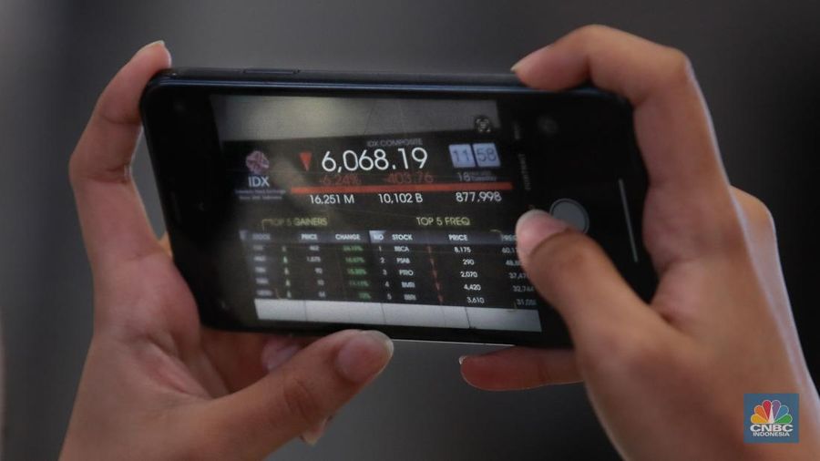 Pengunjung berbincang dibawah layar pergerakan Indeks Harga Saham Gabungan (IHSG) di Bursa Efek Indonesia (BEI), Jakarta, Selasa (18/3/2025). (detikai.com/Muhammad Sabki)