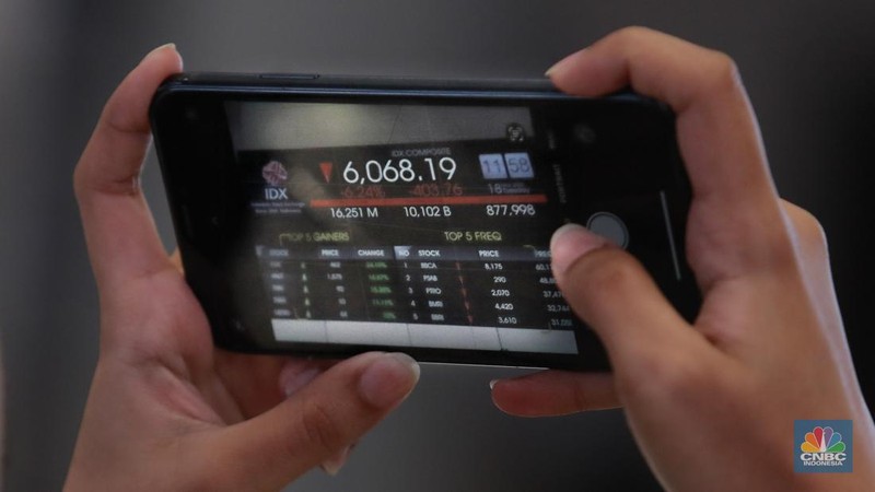 Pengunjung berbincang dibawah layar pergerakan Indeks Harga Saham Gabungan (IHSG) di Bursa Efek Indonesia (BEI), Jakarta, Selasa (18/3/2025). (վ/Muhammad Sabki)