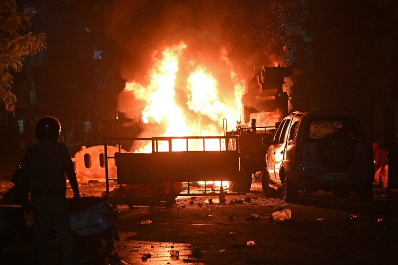 Seorang petugas pemadam kebakaran berdiri di dekat kendaraan yang terbakar setelah bentrokan di kawasan Chitnavis Park Square, Nagpur pada 17 Maret 2025. (AFP) Seorang petugas pemadam kebakaran berdiri di dekat kendaraan yang terbakar setelah bentrokan di kawasan Chitnavis Park Square, Nagpur pada 17 Maret 2025. (AFP)
