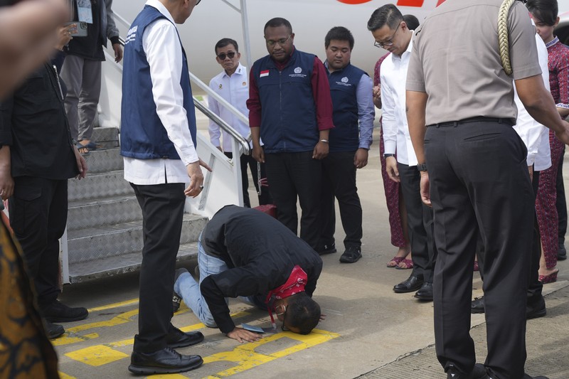 Warga Negara Indonesia yang pernah bekerja di pusat penipuan di Myanmar disambut petugas saat tiba dari Thailand, di Bandara Internasional Soekarno-Hatta di Tangerang, Indonesia, Selasa, 18 Maret 2025. (AP Photo/Tatan Syuflana, Pool)