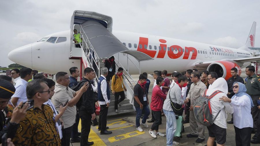 Warga Negara Indonesia yang pernah bekerja di pusat penipuan di Myanmar disambut petugas saat tiba dari Thailand, di Bandara Internasional Soekarno-Hatta di Tangerang, Indonesia, Selasa, 18 Maret 2025. (AP Photo/Tatan Syuflana, Pool)