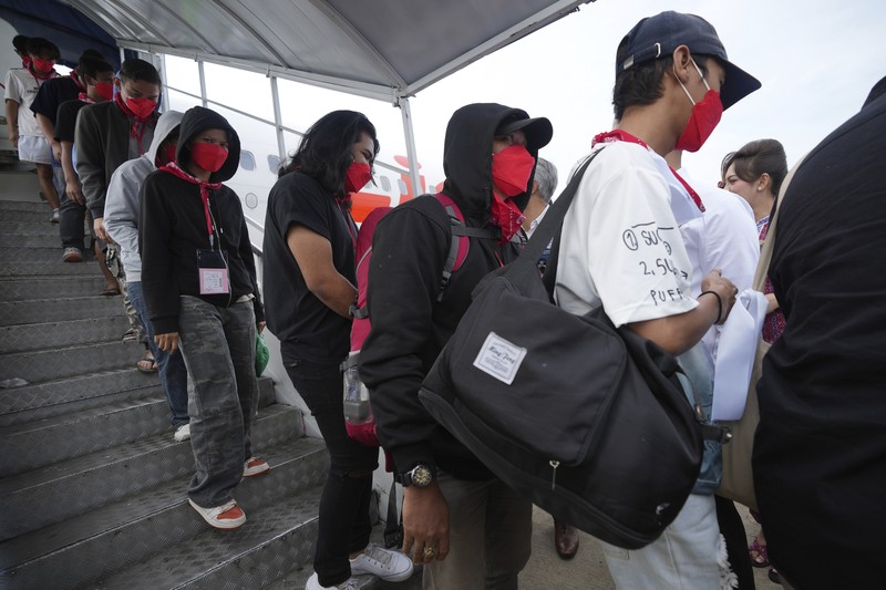 Warga Negara Indonesia yang pernah bekerja di pusat penipuan di Myanmar disambut petugas saat tiba dari Thailand, di Bandara Internasional Soekarno-Hatta di Tangerang, Indonesia, Selasa, 18 Maret 2025. (AP Photo/Tatan Syuflana, Pool)