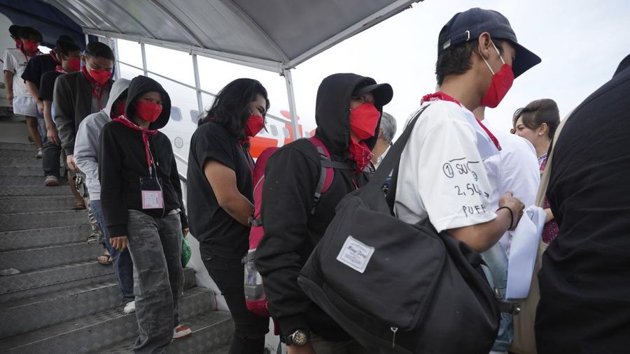 Warga Negara Indonesia yang pernah bekerja di pusat penipuan di Myanmar disambut petugas saat tiba dari Thailand, di Bandara Internasional Soekarno-Hatta di Tangerang, Indonesia, Selasa, 18 Maret 2025. (AP Photo/Tatan Syuflana, Pool)