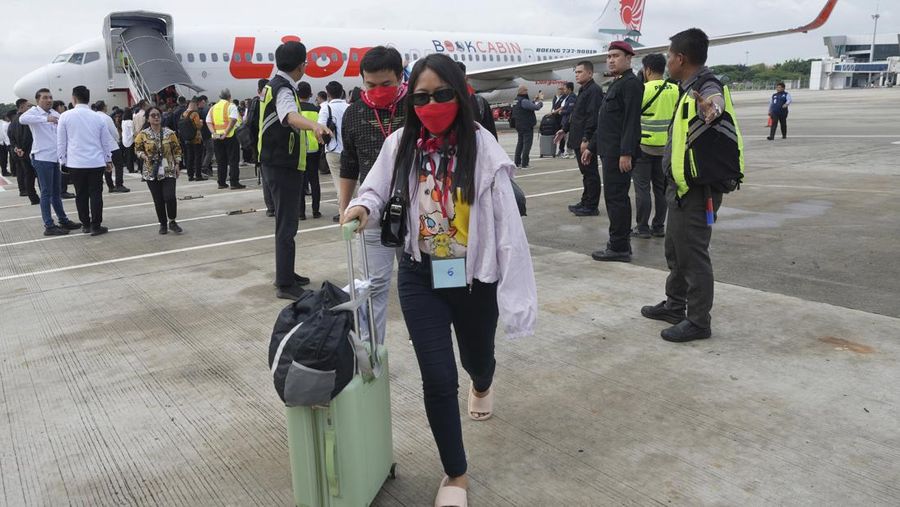 Warga Negara Indonesia yang pernah bekerja di pusat penipuan di Myanmar disambut petugas saat tiba dari Thailand, di Bandara Internasional Soekarno-Hatta di Tangerang, Indonesia, Selasa, 18 Maret 2025. (AP Photo/Tatan Syuflana, Pool)