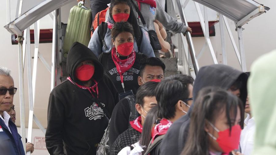 Warga Negara Indonesia yang pernah bekerja di pusat penipuan di Myanmar disambut petugas saat tiba dari Thailand, di Bandara Internasional Soekarno-Hatta di Tangerang, Indonesia, Selasa, 18 Maret 2025. (AP Photo/Tatan Syuflana, Pool)