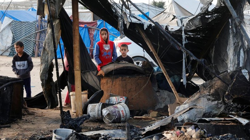 Warga Palestina memeriksa lokasi serangan Israel terhadap kamp tenda yang menampung orang-orang terlantar, di daerah Al-Mawasi, di Khan Younis di Jalur Gaza selatan, 18 Maret 2025. (REUTERS/Hatem Khaled)