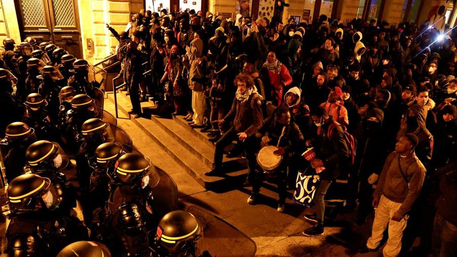 Orang-orang berkumpul menentang pengusiran polisi terhadap para migran dari teater Gaite Lyrique setelah lebih dari tiga bulan pendudukan mereka, di Paris, Prancis, 18 Maret 2025. (REUTERS/Abdul Saboor)