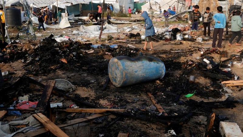 Warga Palestina memeriksa lokasi serangan Israel terhadap kamp tenda yang menampung orang-orang terlantar, di daerah Al-Mawasi, di Khan Younis di Jalur Gaza selatan, 18 Maret 2025. (REUTERS/Hatem Khaled)