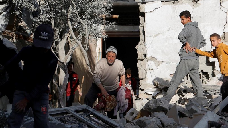 Warga Palestina memeriksa lokasi serangan Israel terhadap kamp tenda yang menampung orang-orang terlantar, di daerah Al-Mawasi, di Khan Younis di Jalur Gaza selatan, 18 Maret 2025. (REUTERS/Hatem Khaled)