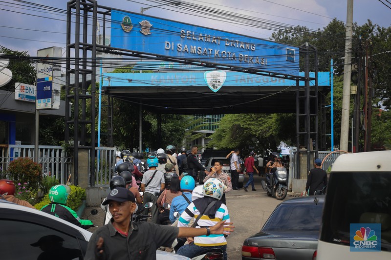 Antrean mengular puluhan kendaraan untuk melakukan pengurusan pajak kendaraan di Samsat Kota Bekasi, Jl. Insinyur H. Juanda, Bekasi, Jawa Barat, Jumat (21/3/2025). (CNBC Indonesia/Tias Budiarto)