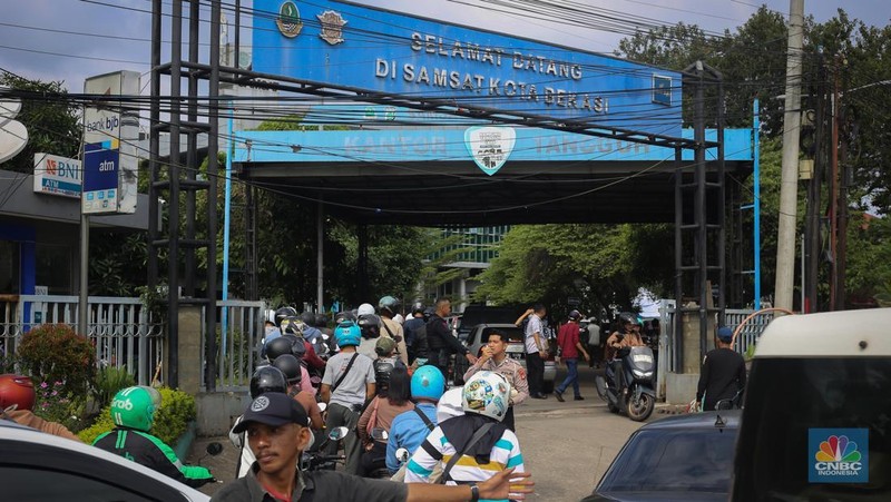 Antrean mengular puluhan kendaraan untuk melakukan pengurusan pajak kendaraan di Samsat Kota Bekasi, Jl. Insinyur H. Juanda, Bekasi, Jawa Barat, Jumat (21/3/2025). (CNBC Indonesia/Tias Budiarto)