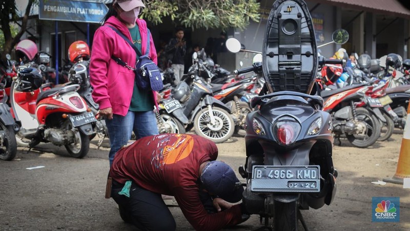 Antrean mengular puluhan kendaraan untuk melakukan pengurusan pajak kendaraan di Samsat Kota Bekasi, Jl. Insinyur H. Juanda, Bekasi, Jawa Barat, Jumat (21/3/2025). (CNBC Indonesia/Tias Budiarto)