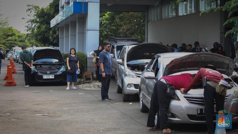 Antrean mengular puluhan kendaraan untuk melakukan pengurusan pajak kendaraan di Samsat Kota Bekasi, Jl. Insinyur H. Juanda, Bekasi, Jawa Barat, Jumat (21/3/2025). (CNBC Indonesia/Tias Budiarto)