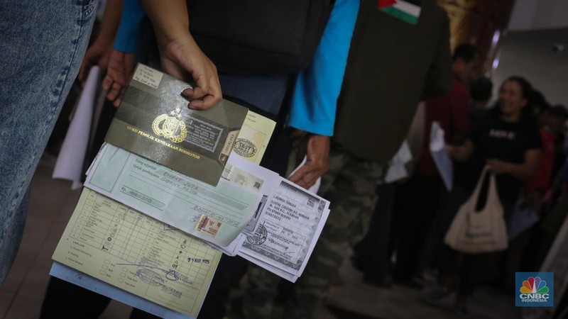 Antrean mengular puluhan kendaraan untuk melakukan pengurusan pajak kendaraan di Samsat Kota Bekasi, Jl. Insinyur H. Juanda, Bekasi, Jawa Barat, Jumat (21/3/2025). (CNBC Indonesia/Tias Budiarto)