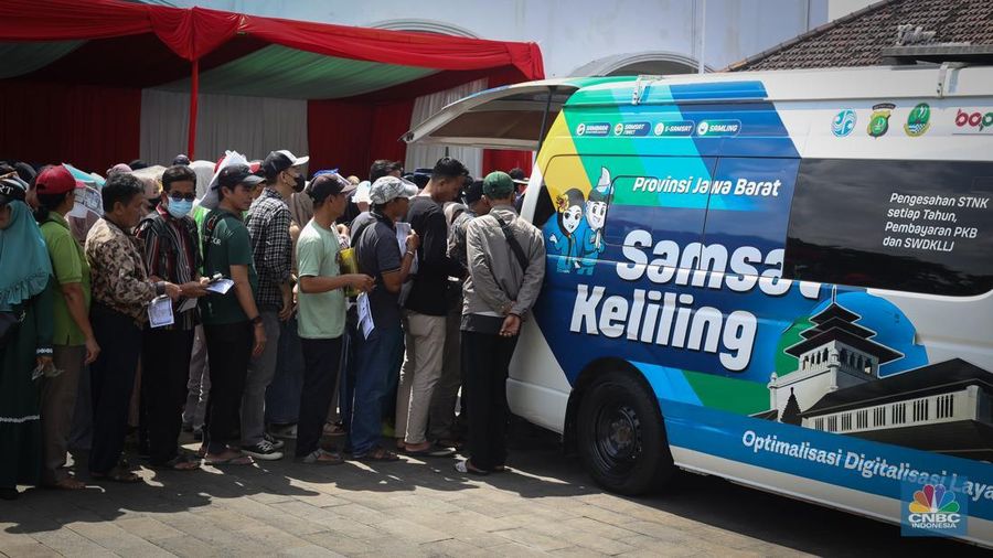 Puluhan warga mengantre pengurusan pajak kendaraan pada mobil Samsat keliling di Gedung Juang, Bekasi, Jawa Barat, Jumat (21/3/2025). (CNBC Indonesia/Tias Budiarto)