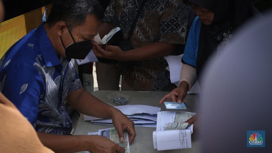 Puluhan warga mengantre pengurusan pajak kendaraan pada mobil Samsat keliling di Gedung Juang, Bekasi, Jawa Barat, Jumat (21/3/2025). (CNBC Indonesia/Tias Budiarto)